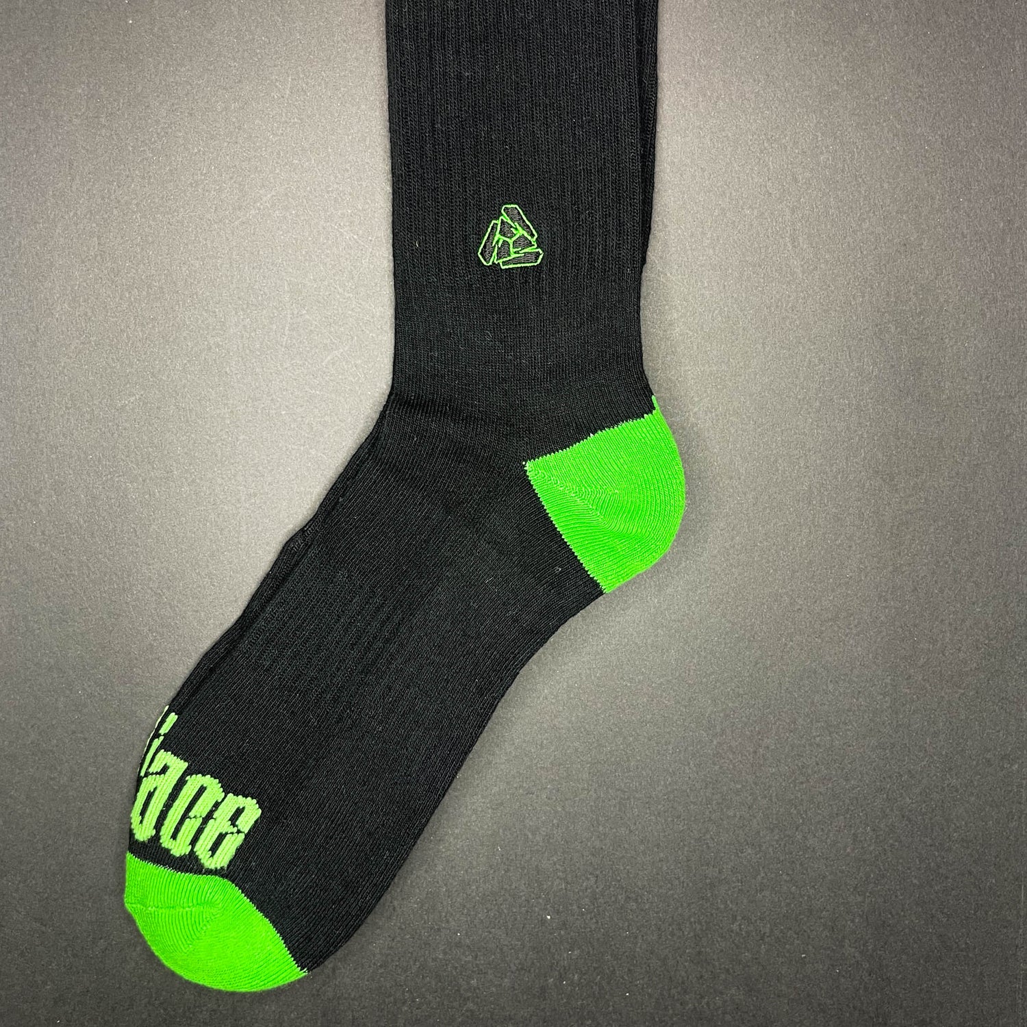 Side view of Menace Clothing Hood Rat green and black knee high socks with Menace on toes and Tri M logo on side.