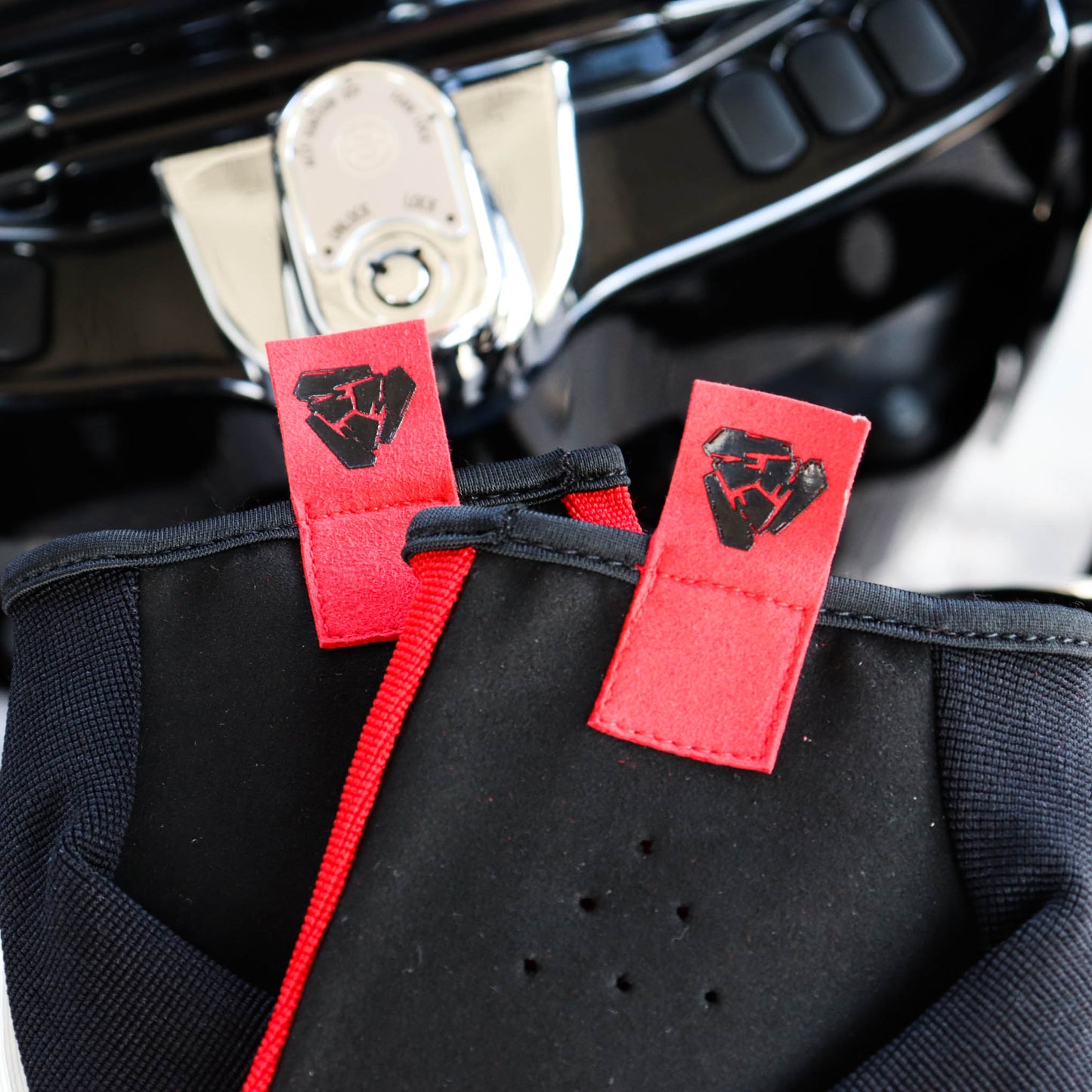 Menace Clothing’s red FTW motorcycle glove’s pull tab with Menace Clothing logo.