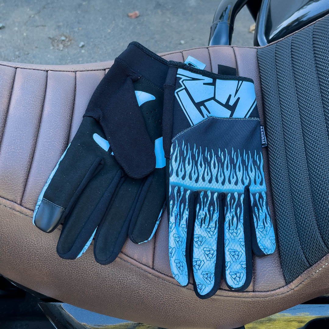 Blue motorcycle gloves on motorcycle seat. Menace Mitts.