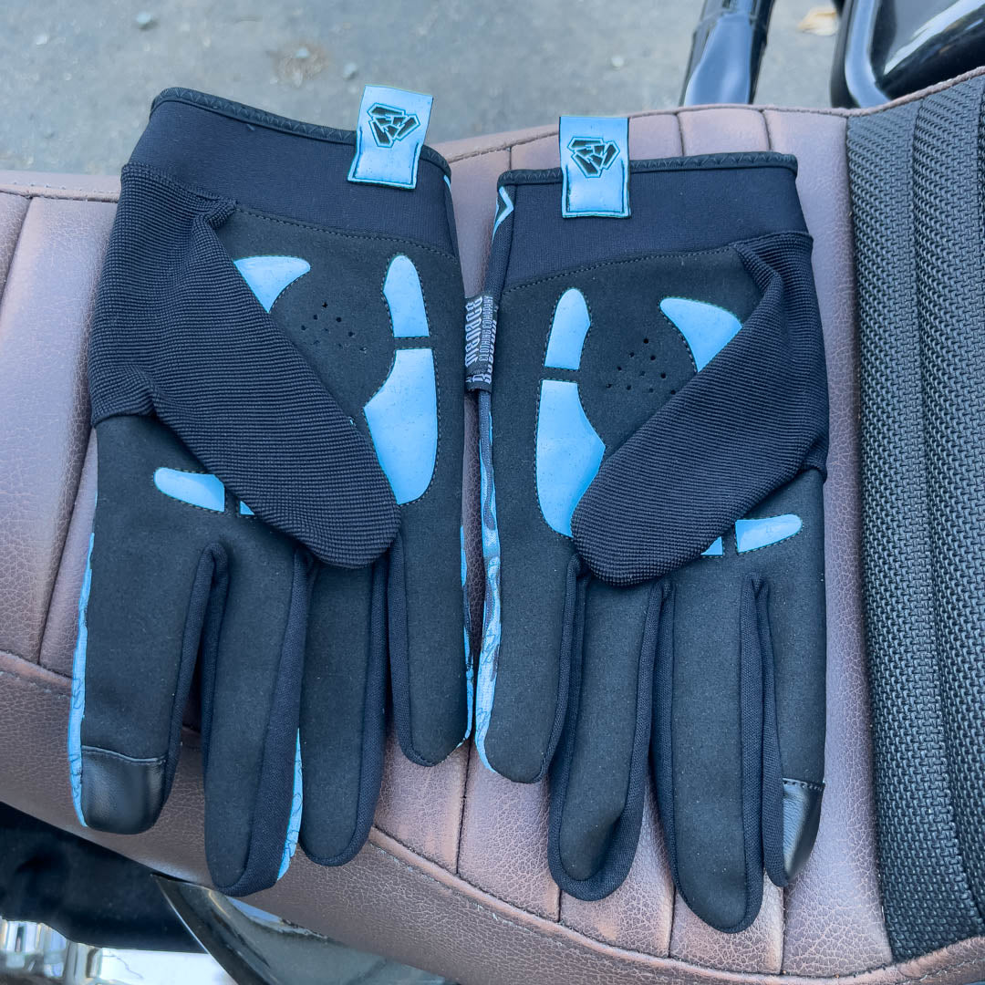 Blue motorcycle glove’s padded palms on motorcycle seat. Menace Mitts.
