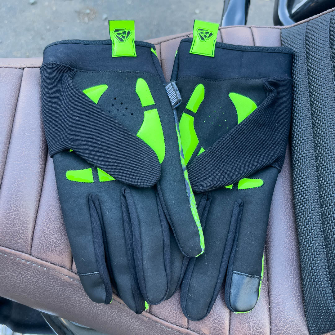Green motorcycle glove’s padded palms on motorcycle seat. Menace Mitts.
